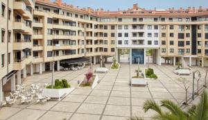 an apartment building with a courtyard with tables and chairs at Ondartxo - ONGI ETORRI in Zumaia