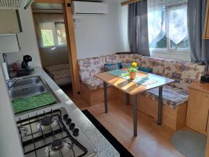 eine Küche und ein Wohnzimmer mit einem Tisch und einem Sofa in der Unterkunft Lexi Zen House in Kamnik