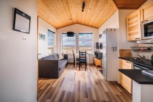 Blue View Cabin 1B With private hot tub في ريكهولت: مطبخ وغرفة معيشة مع أريكة وطاولة