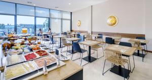 un restaurante con mesas y sillas y un buffet de comida en room Select Porto, en Oporto