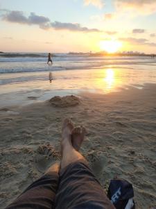 a person laying in the sand on the beach at bugrashov 13 room in Tel Aviv