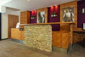 un bar en una habitación con una pared de piedra en Hotel ALPINA, en Saalbach Hinterglemm