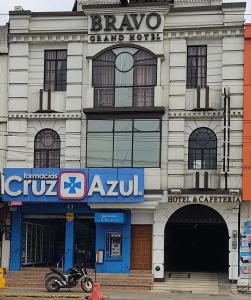 a building with a motorcycle parked in front of it at Hotel - Bravo Grand Hotel in Quevedo