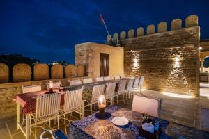 een rij tafels en stoelen op een patio 's nachts bij K D PALACE HOTEL in Jaisalmer
