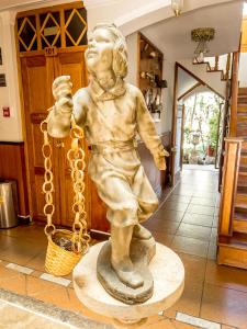 una estatua de un niño sosteniendo una cadena en Hotel Museo Casona Ugarte Leon en Concepción