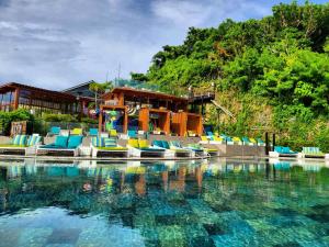 a swimming pool with colorful chairs in front of a resort at Fairways and Bluewater Boracay in Boracay