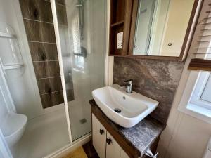 a bathroom with a sink and a shower at Sunflower Hot Tub Lodge in South Cerney