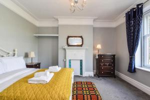 a bedroom with a yellow bed and a mirror at Traditional 3-Bed Property in Pontcanna with Parking in Cardiff