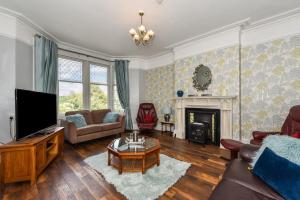 sala de estar con TV y chimenea en Traditional 3-Bed Property in Pontcanna with Parking, en Cardiff