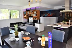 a kitchen and living room with a table and chairs at Villa de charme 4 étoiles avec piscine privée et clim 8 pers près du lac de Parentis in Parentis-en-Born