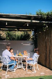 rodzina siedząca przy stole na patio w obiekcie Indigo by The Oyster Collection w mieście Kenton-on-Sea
