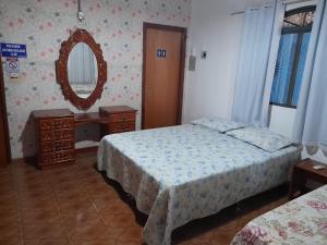 クイアバにあるHostel Aconchego do Lar - CPA 1のベッドルーム1室(ベッド2台、鏡付)