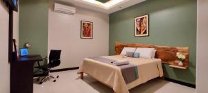 a bedroom with a bed and a desk and a computer at Hotel - Bravo Grand Hotel in Quevedo