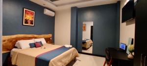 a bedroom with a bed and a desk and a television at Hotel - Bravo Grand Hotel in Quevedo +4 photos