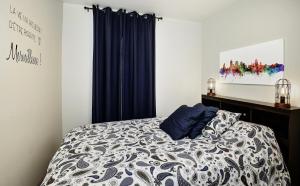 a bedroom with a bed with blue curtains at Condo 105 33 Chemin du Hameau by Les Chalets Alpins in Stoneham