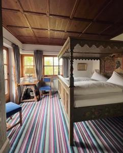 Schlafzimmer mit einem Bett, einem Schreibtisch und einem Tisch in der Unterkunft Hotel Schrenkhof in Unterhaching