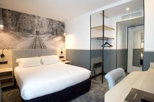 um quarto de hotel com uma cama e uma secretária em Appia La Fayette em Paris