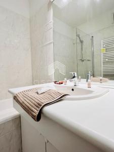 a white bathroom with a sink and a mirror at Reposant à 100 m de la mer.. C.L.S Deauville in Tourgeville