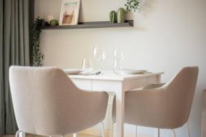 uma mesa com duas cadeiras e uma mesa branca com copos de vinho em Central studio in The Greens 10min to MetroStation em Dubai