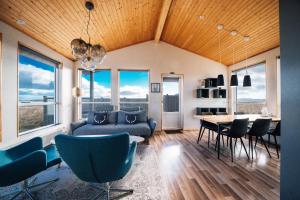 un soggiorno con divano, tavolo e sedie di Blue View Cabin 5A With private hot tub a Reykholt