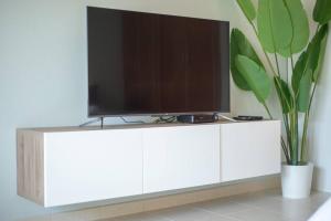 a television on a white cabinet in a living room at Central studio in The Greens 10min to MetroStation in Dubai