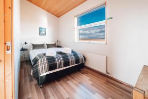 1 dormitorio con cama y ventana en Blue View Cabin 5A With private hot tub en Reykholt