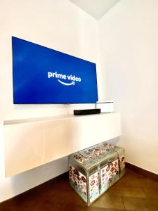 a flat screen tv on a white wall with a box at APPARTAMENTO ELISA in Levico Terme