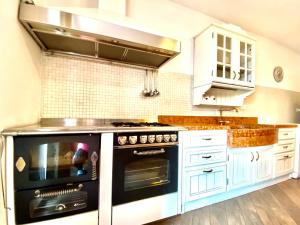 a kitchen with a black oven and white cabinets at APPARTAMENTO ELISA in Levico Terme +6 photos