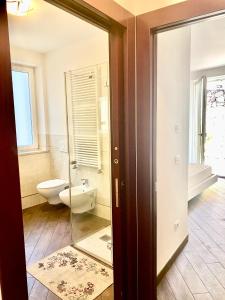 a bathroom with a toilet and a mirror at APPARTAMENTO ELISA in Levico Terme