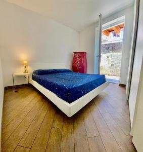a bedroom with a bed with a blue comforter at APPARTAMENTO ELISA in Levico Terme