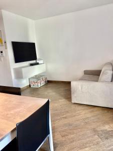 a living room with a bed and a television at APPARTAMENTO ELISA in Levico Terme