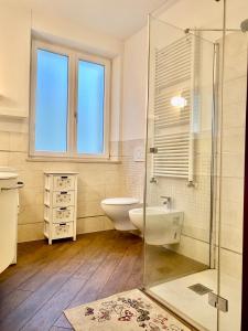 uma casa de banho com um WC e uma cabina de duche em vidro. em APPARTAMENTO ELISA em Levico Terme