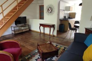 a living room with a couch and a table and a kitchen at Le nid d'Eugénie in Blaudeix