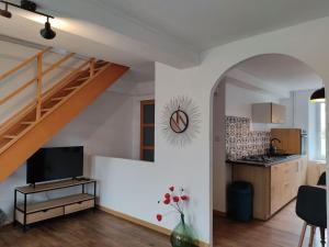 a living room with a staircase and a kitchen at Le nid d'Eugénie in Blaudeix