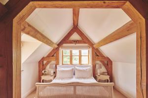 an attic bedroom with a bed and a window at Apple Tree Cottage in Beckford