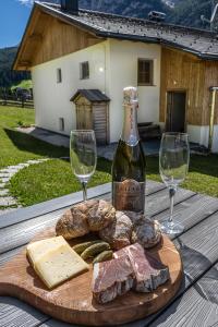 un plato de carne y queso y dos copas de vino en Apartements Precalalt, en La Villa