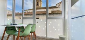 a table and chairs in a room with a window at Suite by Hawkins Exterior 2B in Algeciras