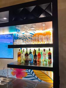 - une étagère avec des bouteilles d'alcool et des verres dans l'établissement Puma Resort Hotel, à Doctor Juan León Mallorquín