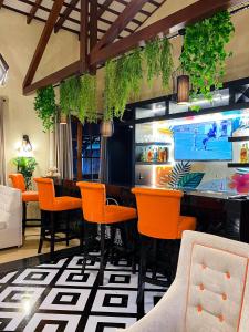 un restaurant avec des chaises orange et un bar dans l'établissement Puma Resort Hotel, à Doctor Juan León Mallorquín