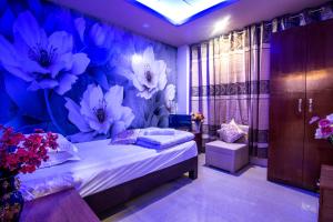 a bedroom with a bed with flowers on the wall at Hotel Pushpo Bilash in Khulna
