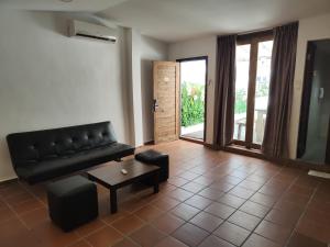 a living room with a black leather couch and a table at Armenian Suite in George Town