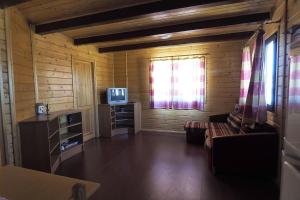 a living room with a couch and a television at Cozy House with Private Pool (Lago) in Arenas