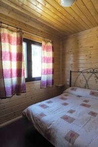 a bedroom with a bed in a wooden cabin at Cozy House with Private Pool (Lago) in Arenas