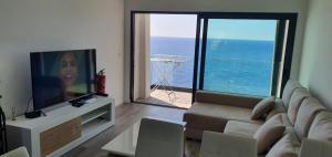 ein Wohnzimmer mit einem Sofa und einem großen Fenster in der Unterkunft Apartamento T2-5m Aeroporto CR7 in Santa Cruz