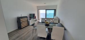 a dining room with a table and chairs and a window at Apartamento T2-5m Aeroporto CR7 in Santa Cruz