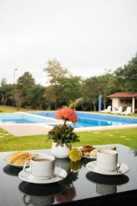 a table with two cups of coffee and plates of food at Puma Resort Hotel in Doctor Juan León Mallorquín
