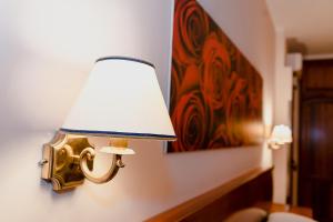 a lamp attached to a wall with a painting at Garibaldi Home in Frosinone