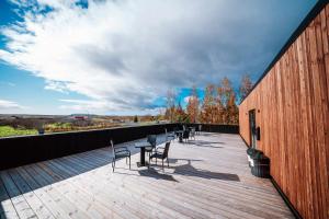 a deck with chairs and a table on a building at Blue Hotel Fagrilundur - On The Golden Circle in Reykholt