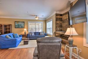 a living room with blue furniture and a stone wall at Sunset Cove Condo Access to Lake Sinclair in Sparta