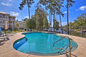a swimming pool at a apartment complex with trees at Sunset Cove Condo Access to Lake Sinclair in Sparta